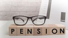 Glasses on top of blocks spelling out pension