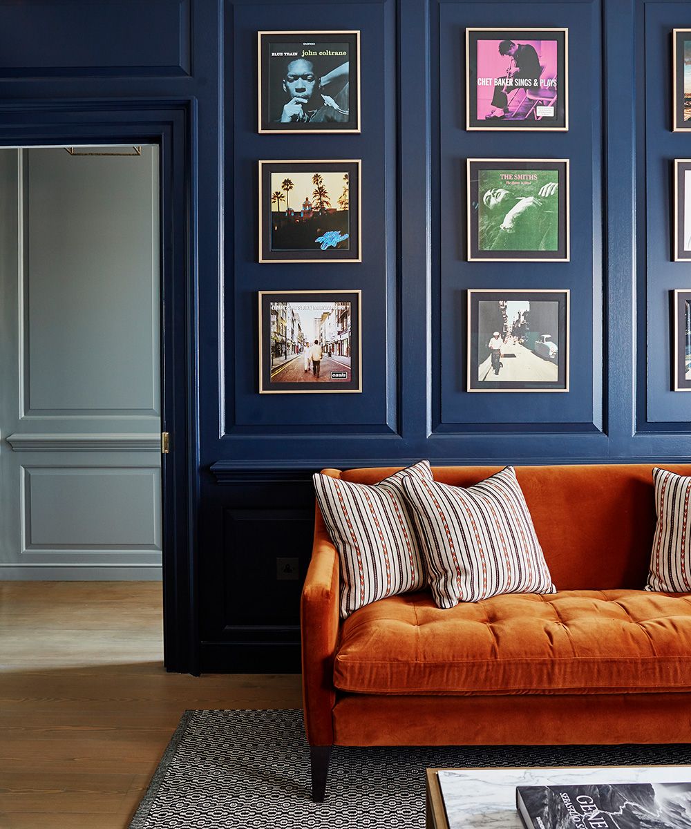 Living room paint ideas Blue panelled living room with orange sofa
