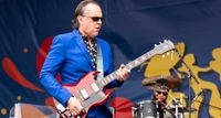 Joe Bonamassa wears shades, a bright blue suit and polka-dot short, as he plays a Gibson SG onstage during an opening slot for the Rolling Stones.