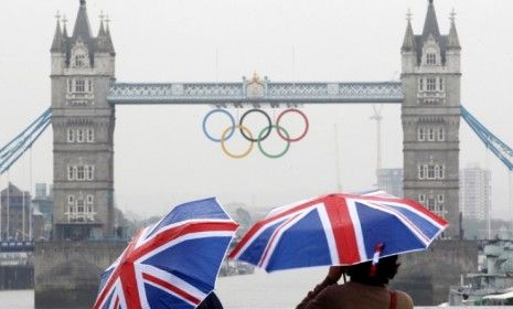 Tourists stand under Union Jack umbrellas