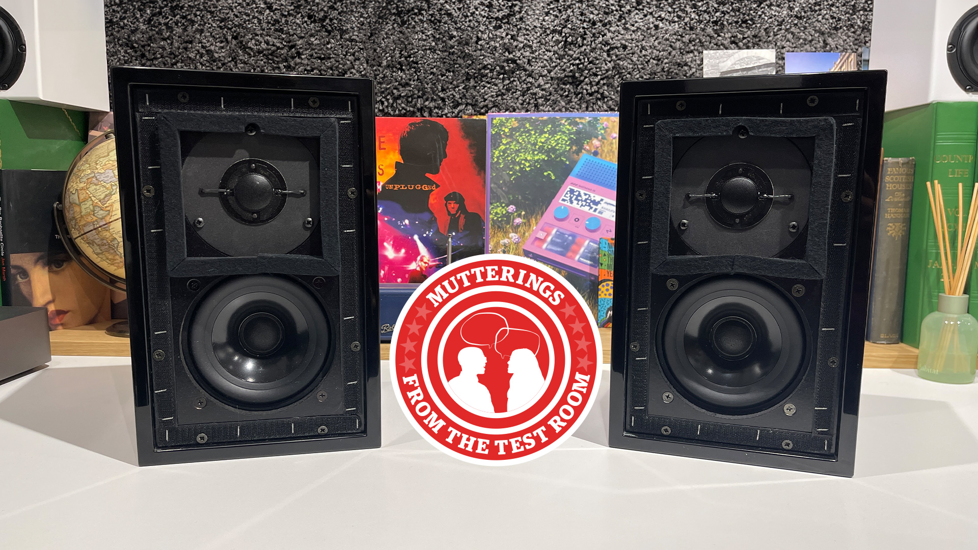 KEF LS3/5A piano black speakers on a white desk