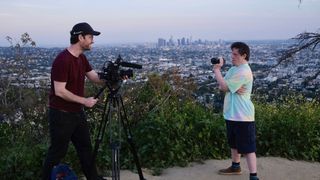 Will Jessop in a red top and Tommy Jessop in a blue top film each other on a hill overlooking LA in Tommy Jessop Goes to Hollywood.