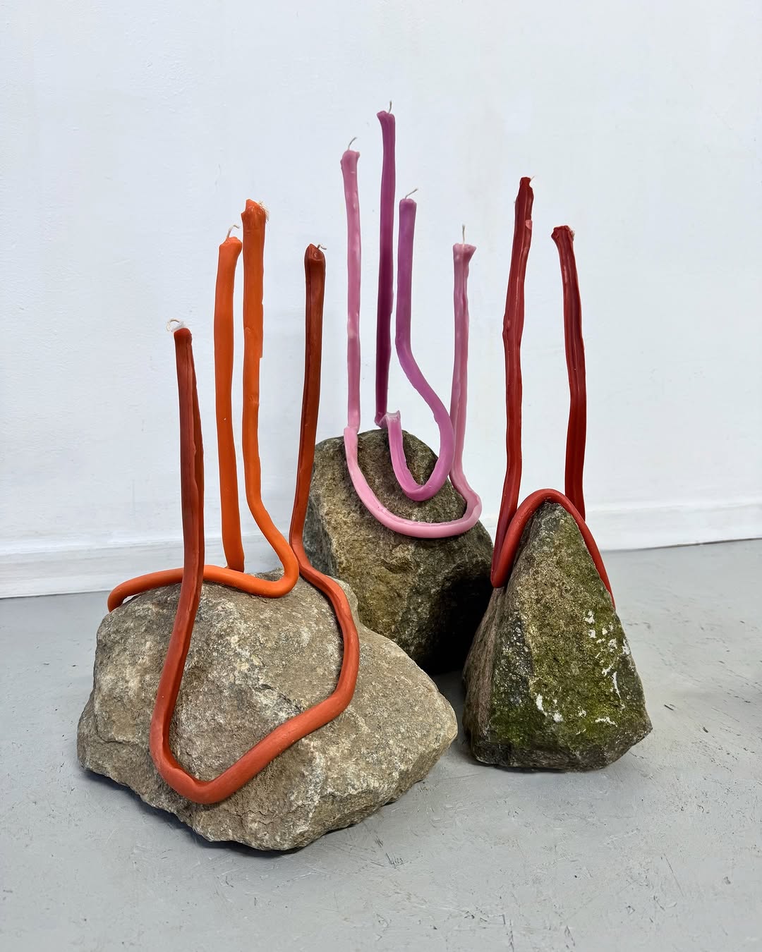 Candles standing half-melted on rocks