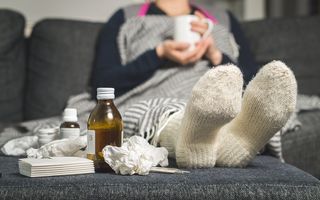 A person sick with a cold sitting on couch.