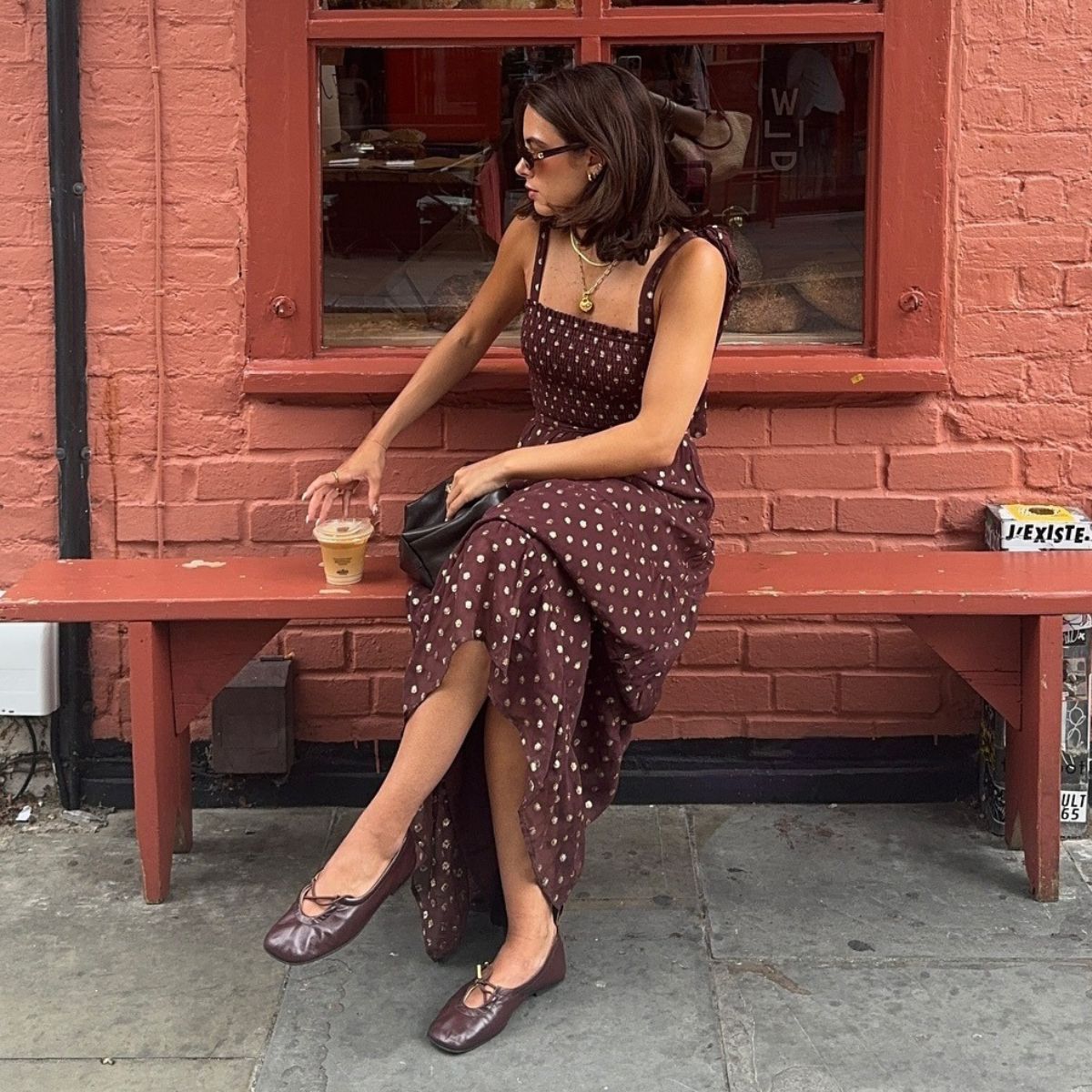 Woman wears polka dot dress, brown Alohas Rosalind ballet flats