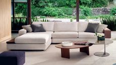 Image of a modern, memory foam section in beige in a modern living room. There is a nesting coffee table and grey throw pillows on the sofa.