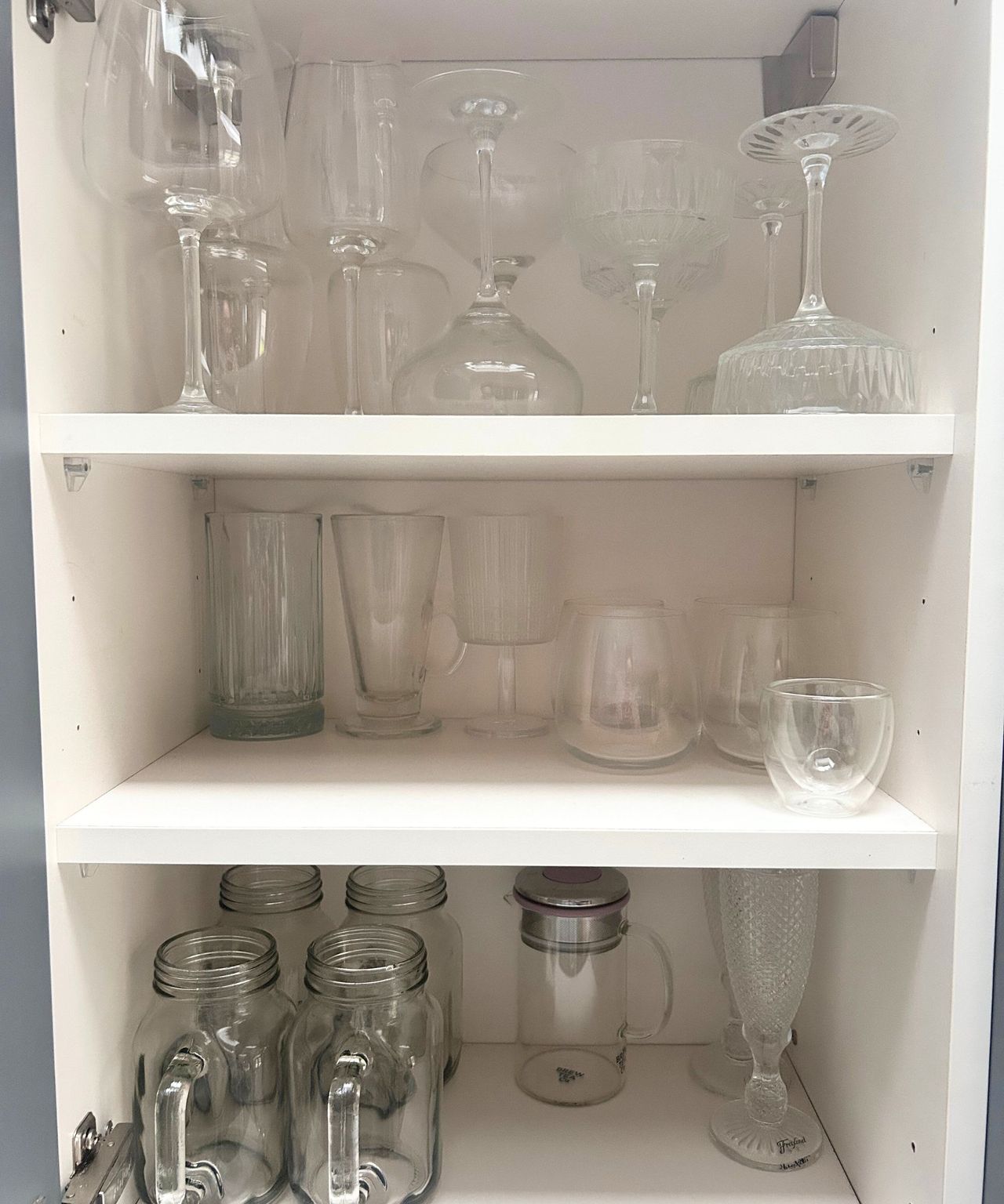 A kitchen cupboard with organized glassware