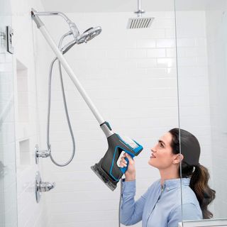 Woman cleaning shower with the Bissell PowerFresh SlimSteam