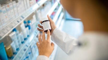 woman looking at supplements in a pharmacy