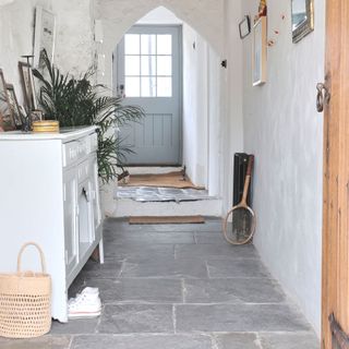 white walled hallway with slate floors