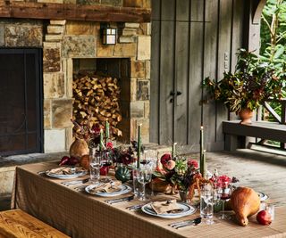 fall garden room display with a long tablescape featuring candles foliage and gourds