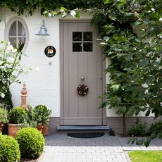 front door with potted plants and stone flooring