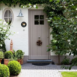 front door with potted plants and stone flooring