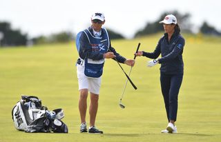 Boutier hands a club over to her caddie