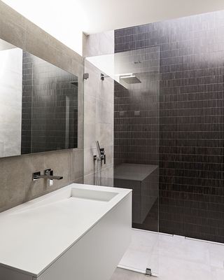 Bathroom with black mosaic tiles and white basin