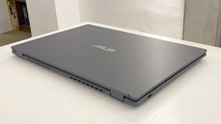 Asus Chromebook Plus laptop closed with the screen on, sitting on a desk
