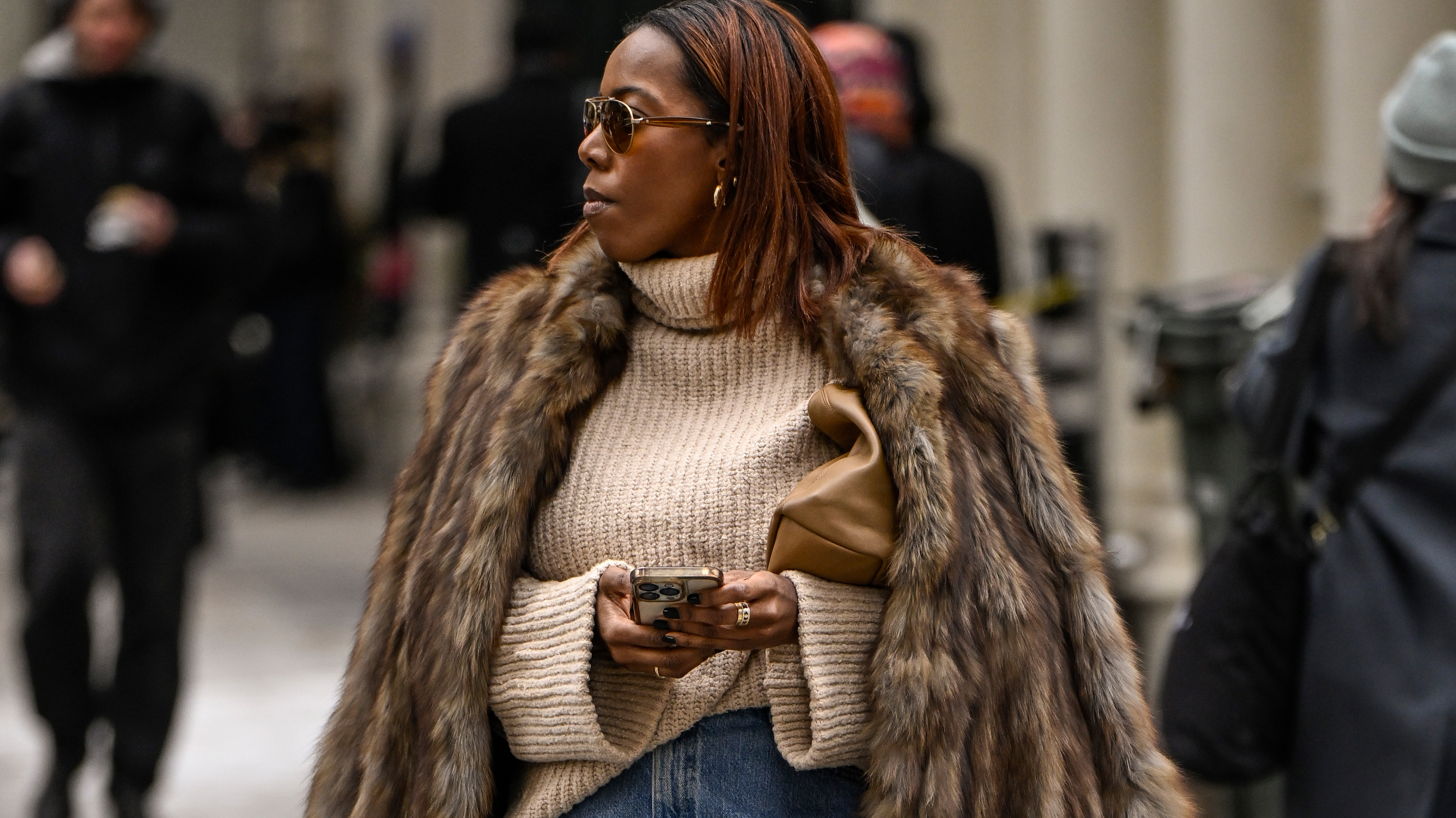 NEW YORK, NEW YORK - FEBRUARY 11: Tiffany Reid is seen wearing a brown fur coat, cream sweater, jean skirt, brown heels and tan bag outside the Kallmeyer show during NYFW F/W 2025 on February 11, 2025 in New York City. 