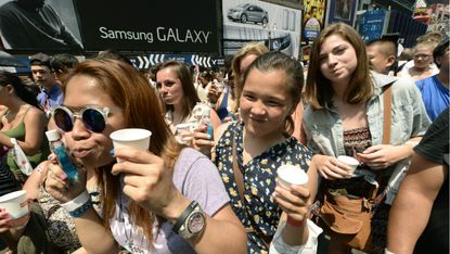 Hundreds of people rinse with mouthwash in Times Square June 25, 2013 during an event to promote Colgate-Palmolive Co.'s Colg