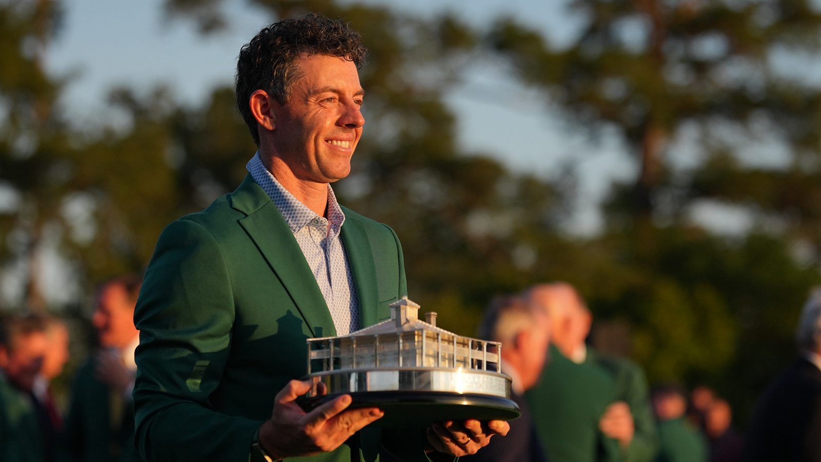 Rory McIlroy holds The Masters trophy and wears a Green Jacket