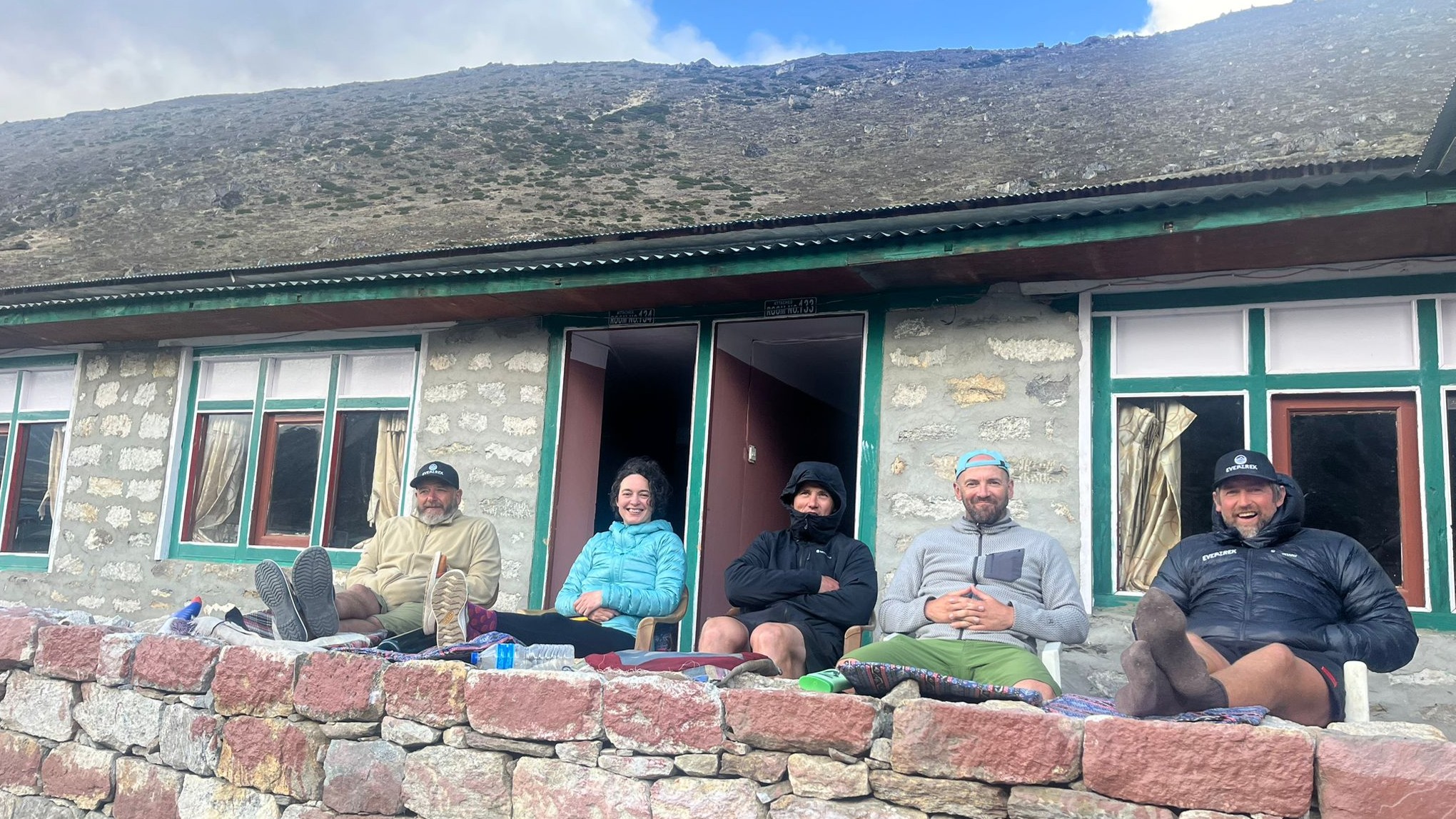 Five trekkers on the way to Everest Base Camp relax outside their teahouse
