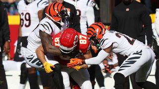 Travis Kelce #87 of the Kansas City Chiefs runs with the ball as Germaine Pratt #57 and Chidobe Awuzie #22 of the Cincinnati Bengals defend in the AFC Championship Game at Arrowhead Stadium on January 30, 2022 in Kansas City, Missouri.