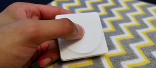 A hand is shown pressing the Logitech POP Smart Button.