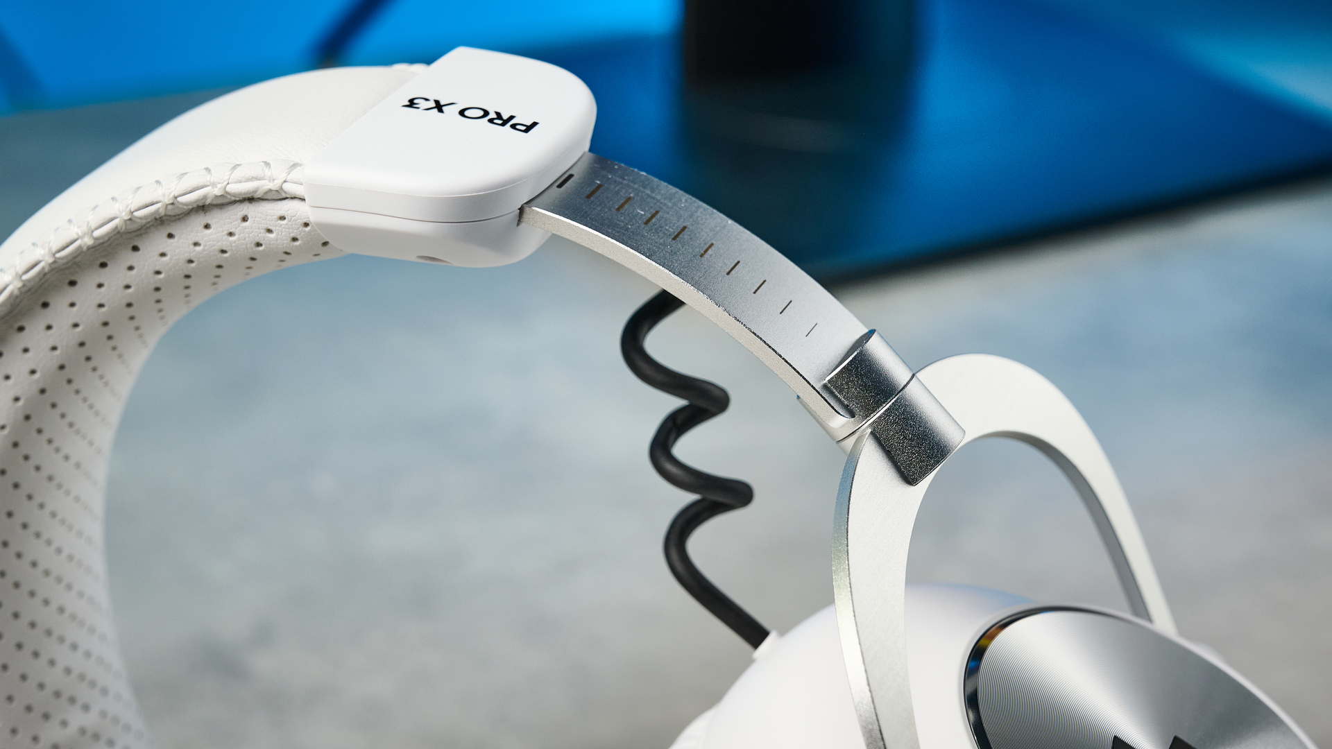The Logitech G Pro X3 Lightspeed headset in white, on a stone surface.