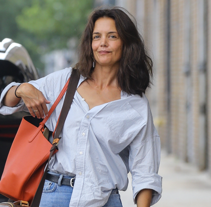 Katie Holmes was spotted running errands in New York City wearing a white shirt, mom jeans, and black flats. The actress completed her casual look with Louis Vuitton and Tod's bags, along with an orange tote.