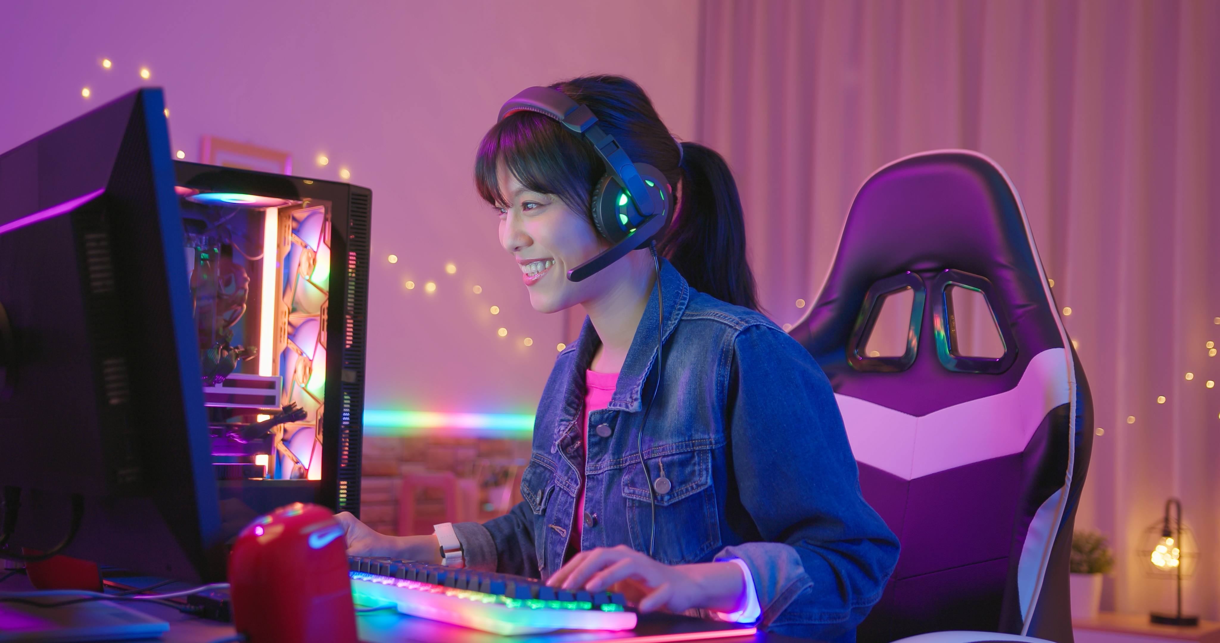 aziatische vrouw die een headset draagt, is aan het chatten met de speler terwijl hij thuis een online videogame speelt