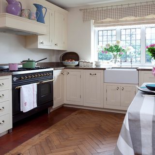 kitchen area with wooden floor and white kitchen units