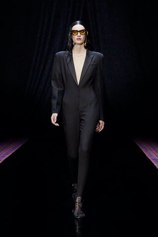 A fashion model in a black dress coat