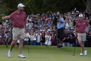 Marc Leishman fist pumps whilst Cameron Smith looks on