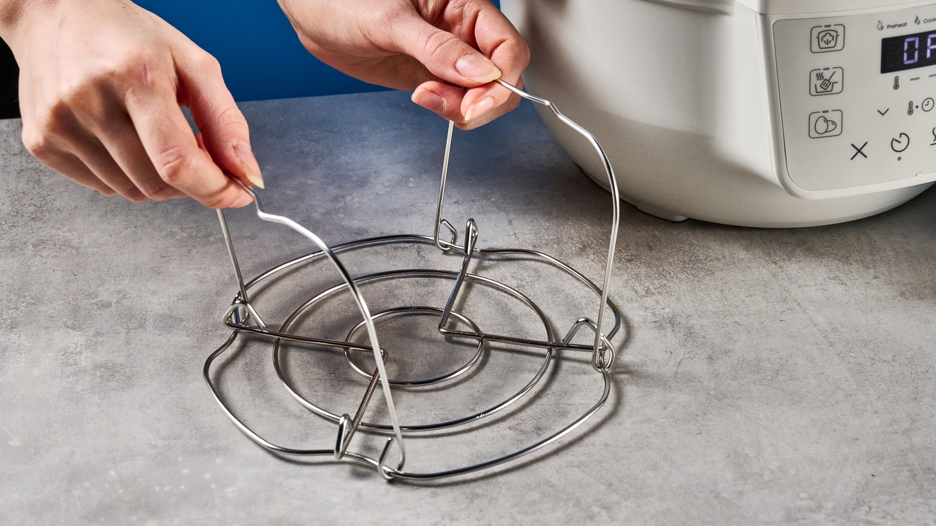 the instant pot rio mini / instant pot mini in white photographed against the blue tom's guide background showing its inner pot, accessories, and cooking programs
