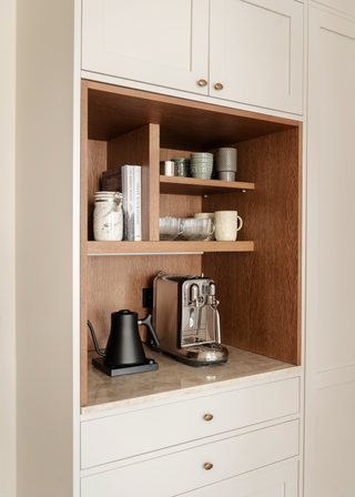 a coffee corner within a pocket door cupboard in a white cabinetry kitchen