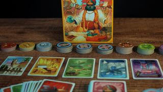 The box, tokens, and cards of Jaipur laid out on a wooden table