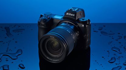 The Nikon Z6,, one of the best cheap full-frame cameras, on a blue background being splashed with water