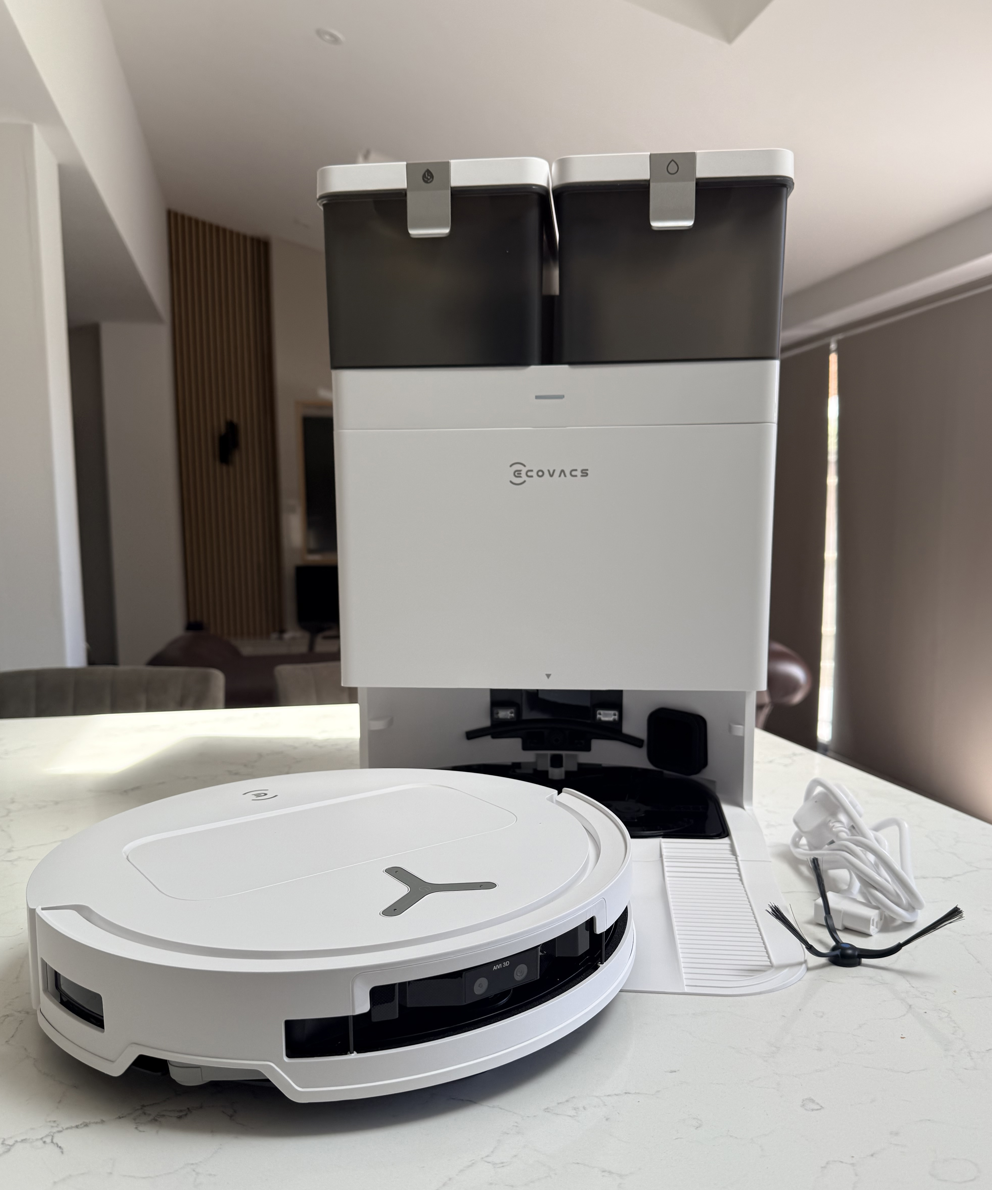 Front-left view of the Ecovacs Deebot T50 Pro Omni robot vacuum beside the OMNI Station