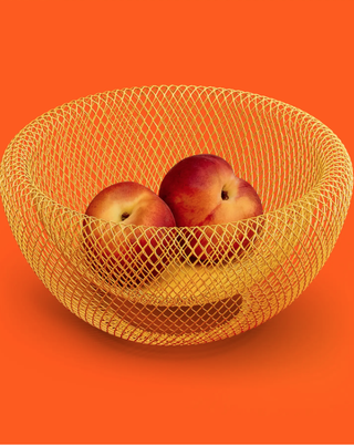 yellow mesh double-layered fruit bowl holding two nectarines on an orange background