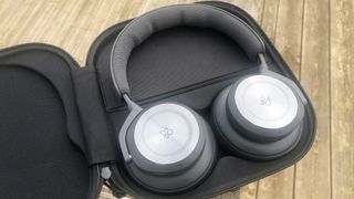 Bang & Olufsen Beoplay HX headphones in an open case on picnic bench 
