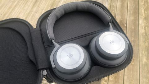 Bang & Olufsen Beoplay HX headphones in an open case on picnic bench 