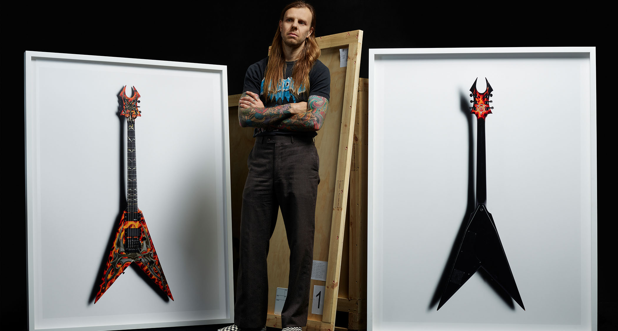 Kane Hibberd, the photographer behind the Scale exhibition in London, poses in front of his photographs – guitars features will include Kerry King of Slayer's BC Rich and Tom Morello's Arm The Homeless S-style.