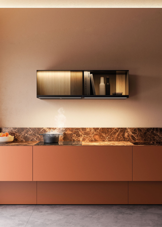 a warm, neutral kitchen with an integrated electric hob and a deep red marble worksurface