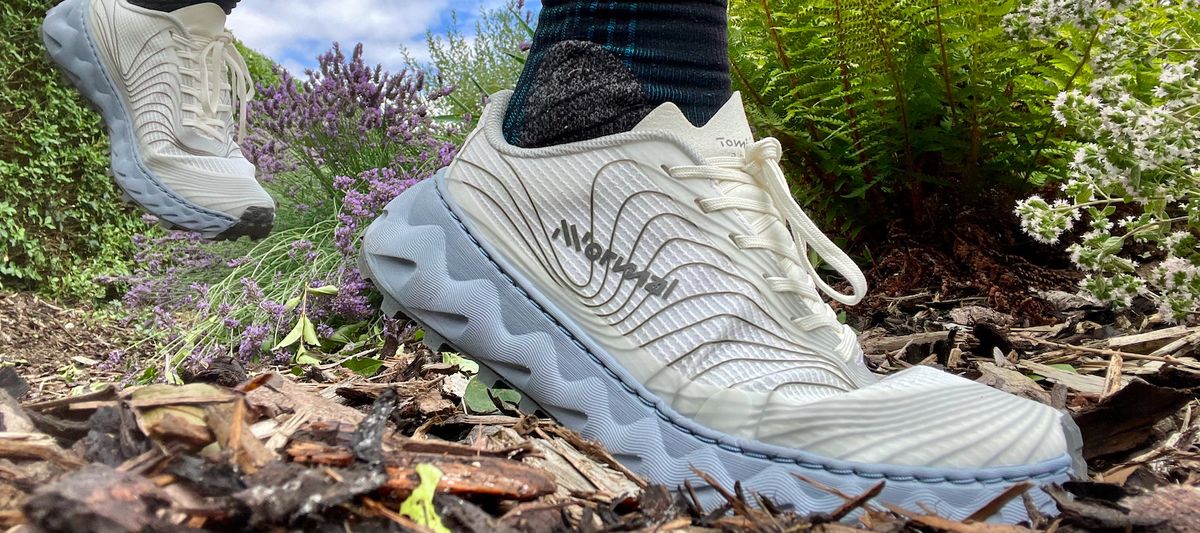 Woman&#039;s feet wearing NNormal Tomir trail running shoes