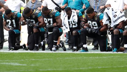 Jacksonville Jaguars players kneel during the U.S. national anthem before a match.