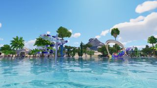 The rippling water of a swimming pool with flumes and tropical plants in the background.