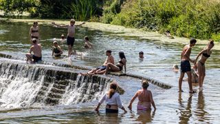 People swimming at a wild swimming spot near Bath, UK