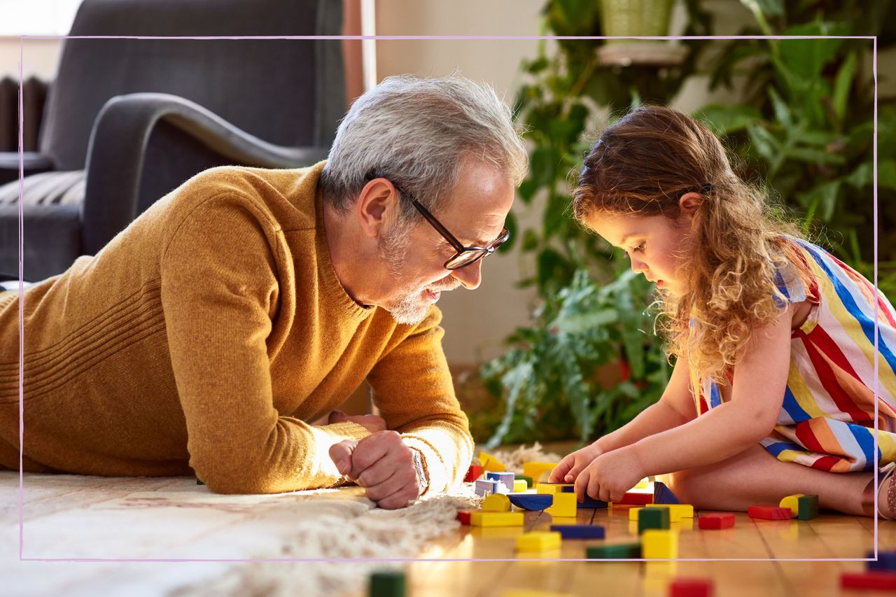 A grandfather playing with a young girl on the floor