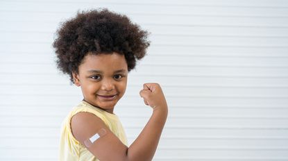 Little boy with bandage on his arm encouraging vaccination.