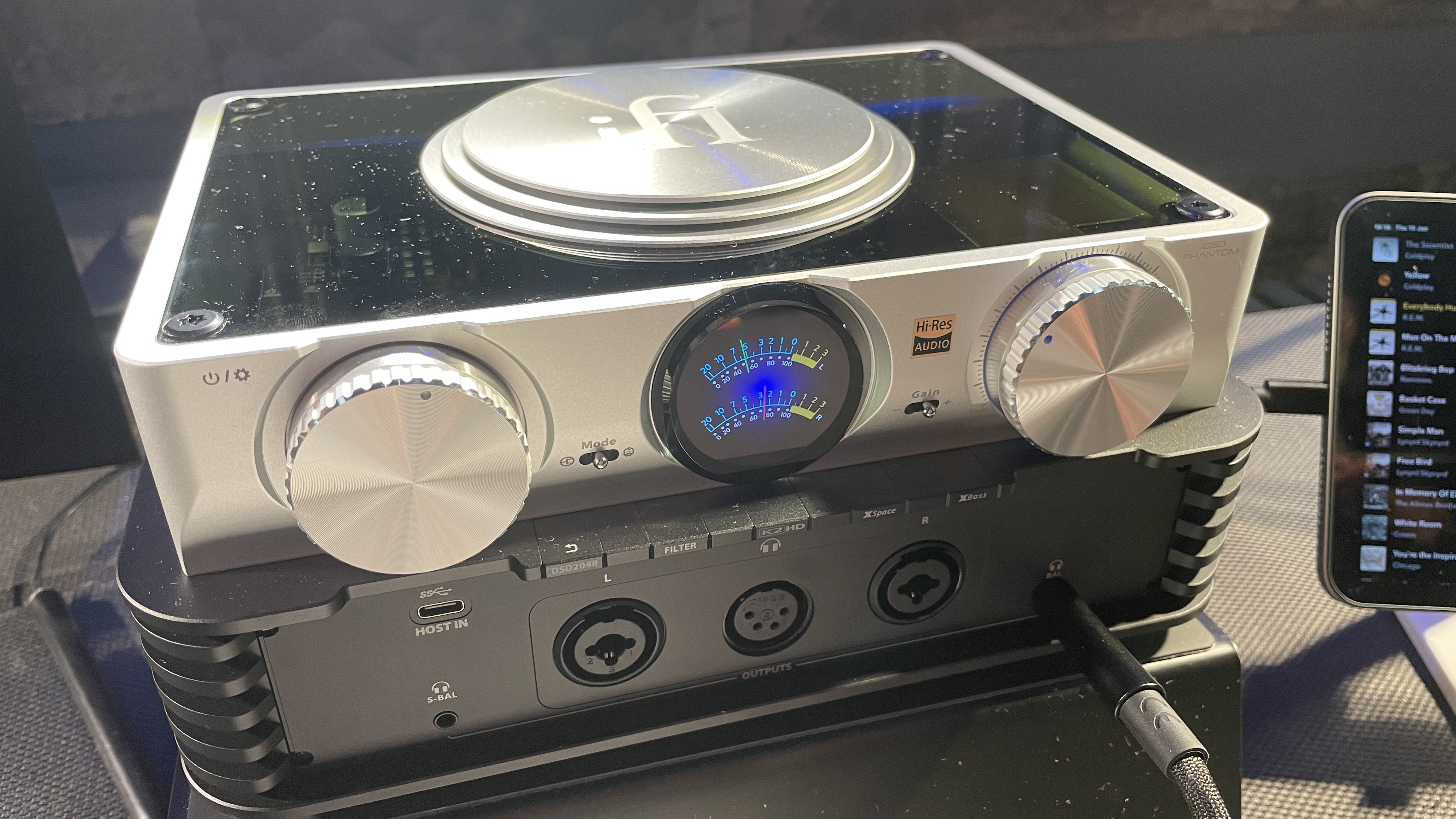 The formidable iFi iDSD Phantom in Tower Bridge, London, used with headphones and illuminating the front panel 