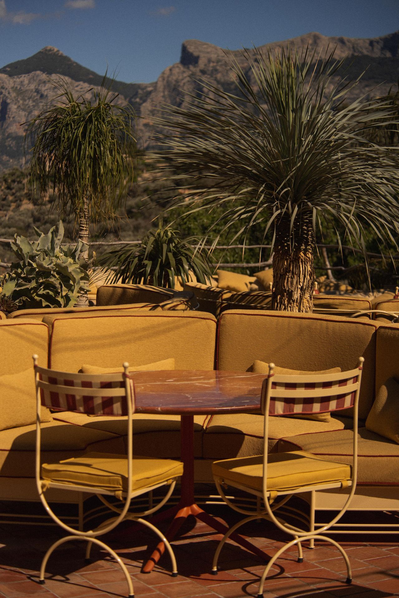 upholstered seating, tables and steel frame chairs on sunny terrace restaurant
